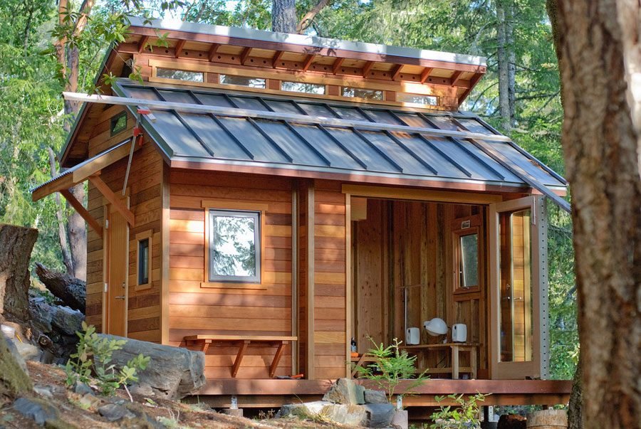 Open-sided cedar cabin in sunlit forest