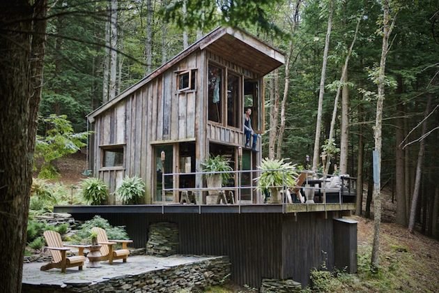 Reclaimed timber cabin with deck in woodland