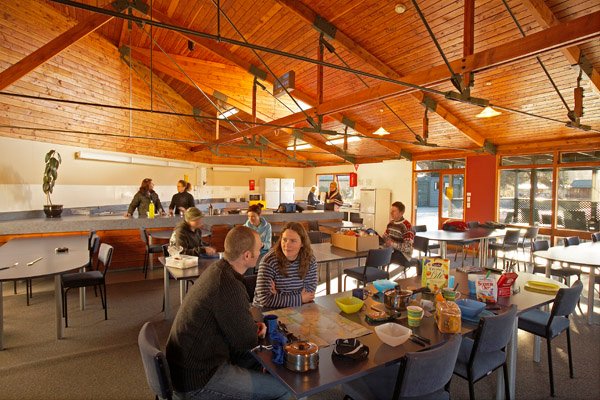 Communal kitchen and dining space with timber ceiling