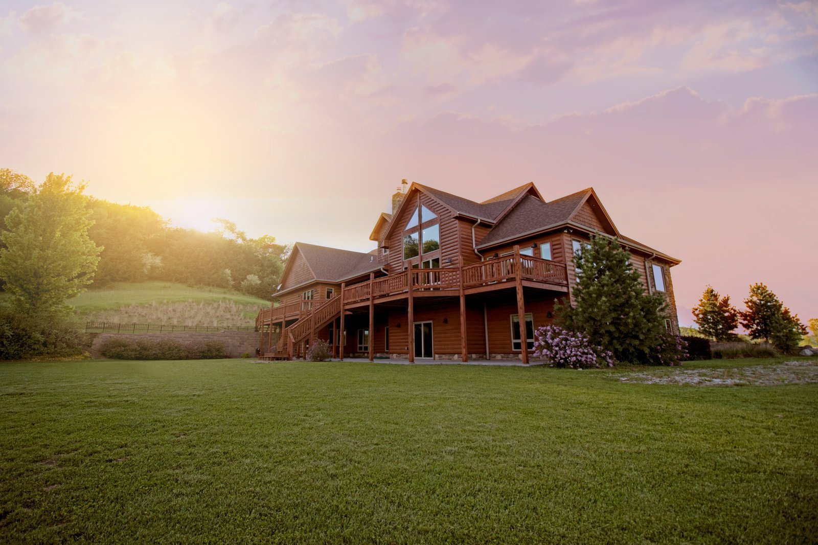 Timber house at golden sunset with open lawn and rolling hills — a sense of home