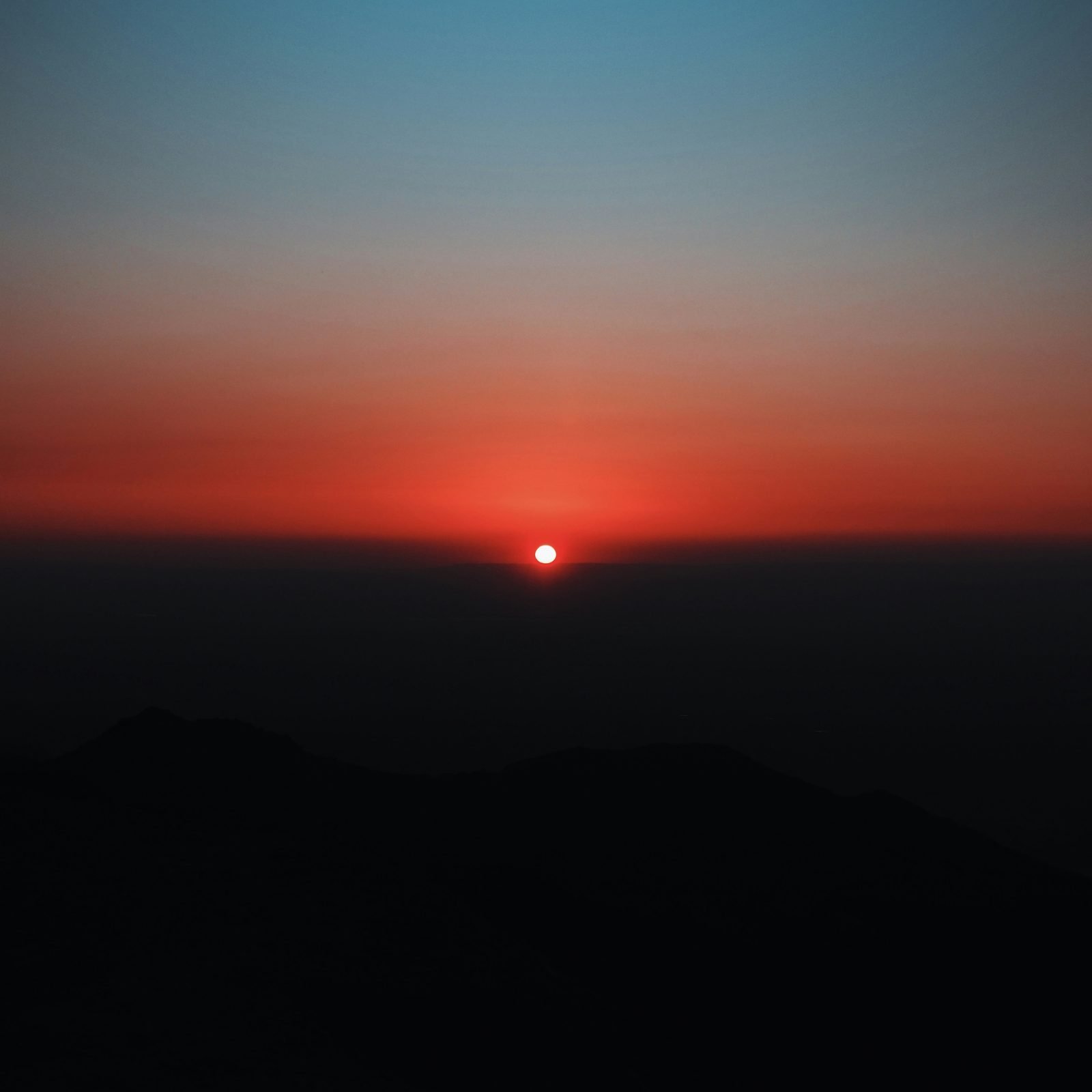 Deep red sunrise on the horizon — the dawn that begins the day at HOME